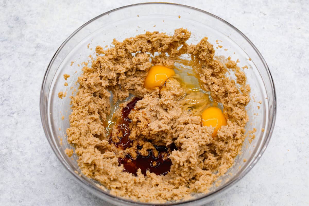 Overhead shot of the creamed butter and sugar in a bowl with eggs and vanilla added. 