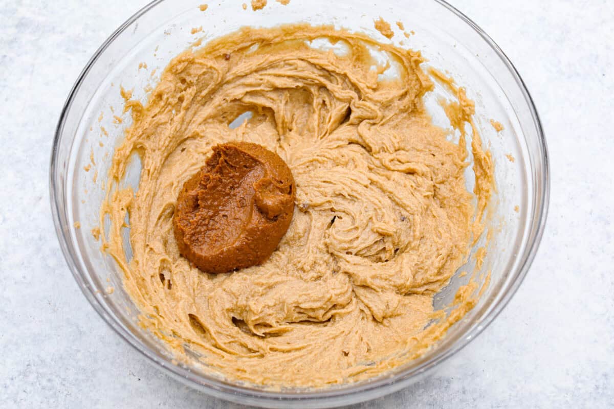 Overhead shot of a bowl of cookie dough with dollop of cookie butter on top. 