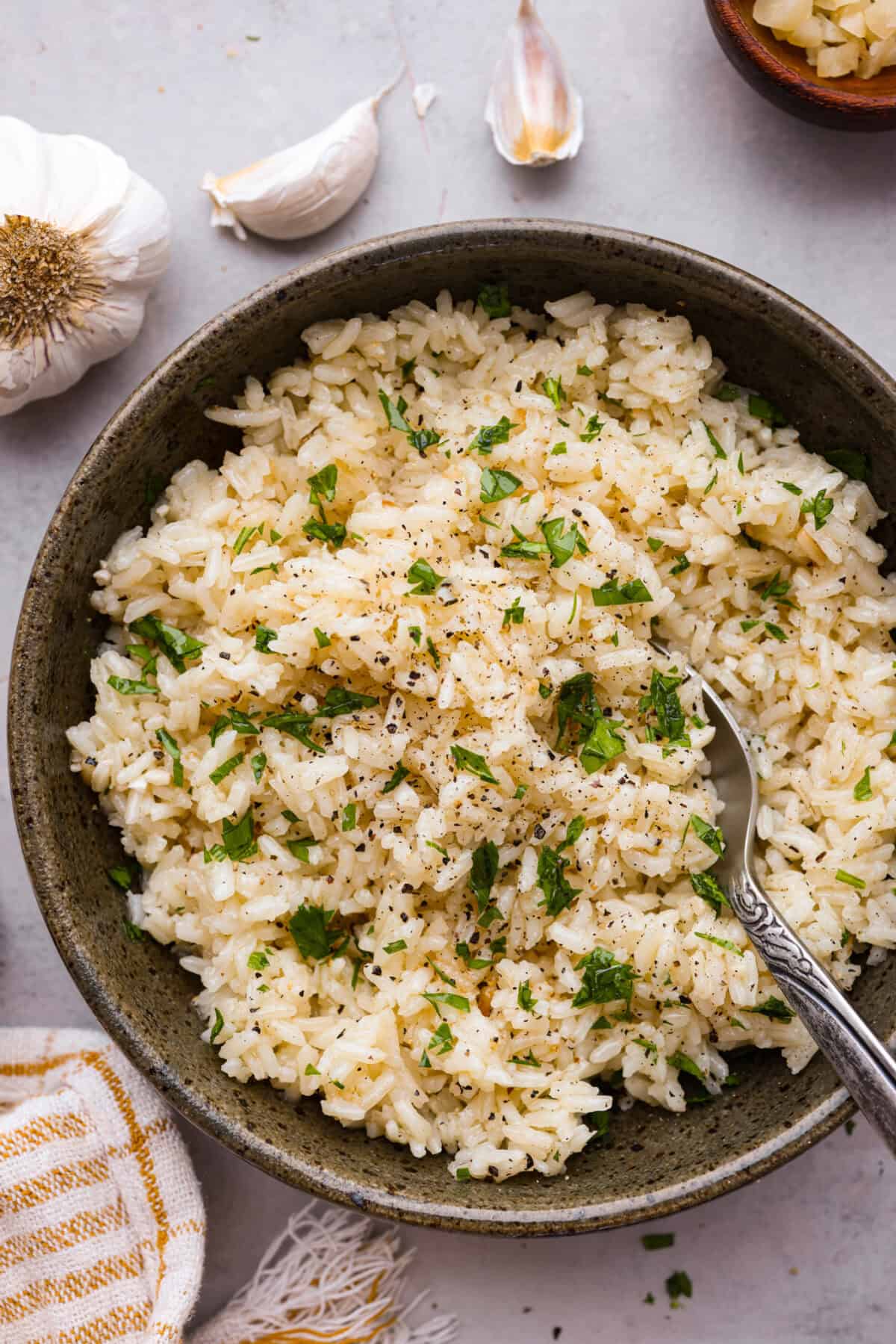 Overhead shot of a bowl of garlic butter rice with a spoon in it.