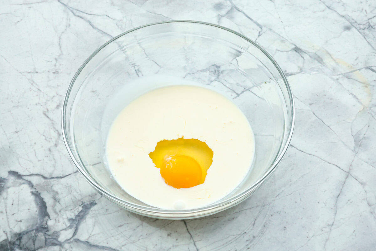 Overhead shot of cream and egg in a glass bowl.