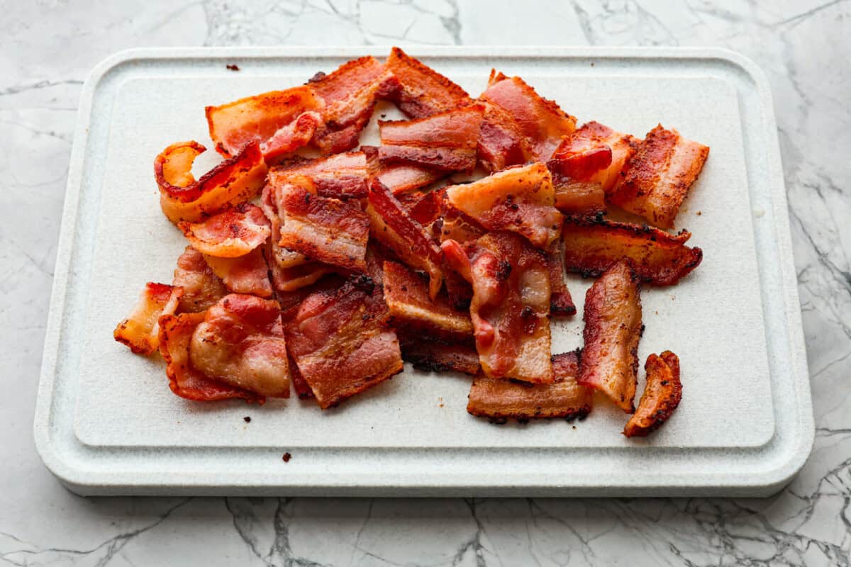 Angle shot of cooke bacon cut on a cutting board. 