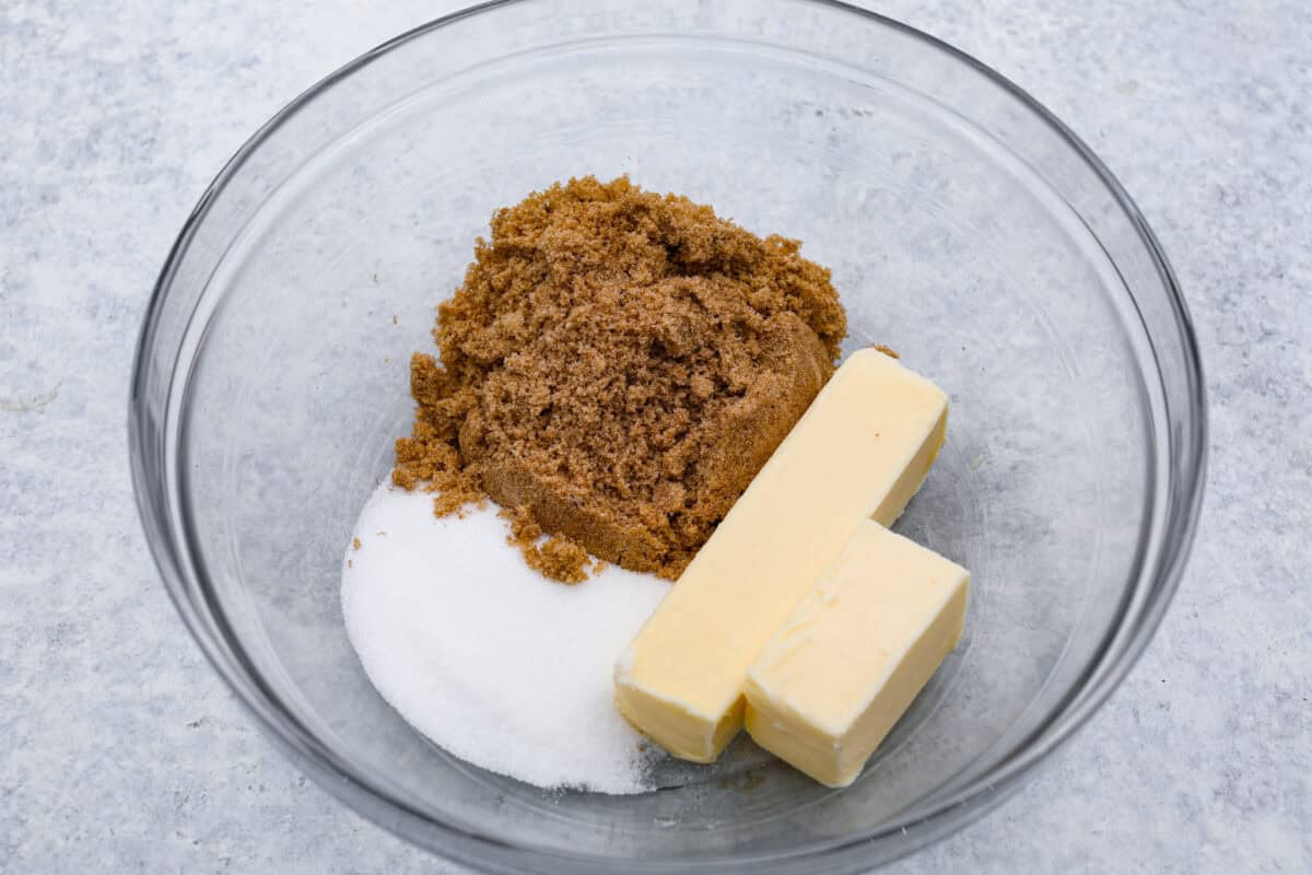 Overhead shot of butter and sugars separated in a mixing bowl. 