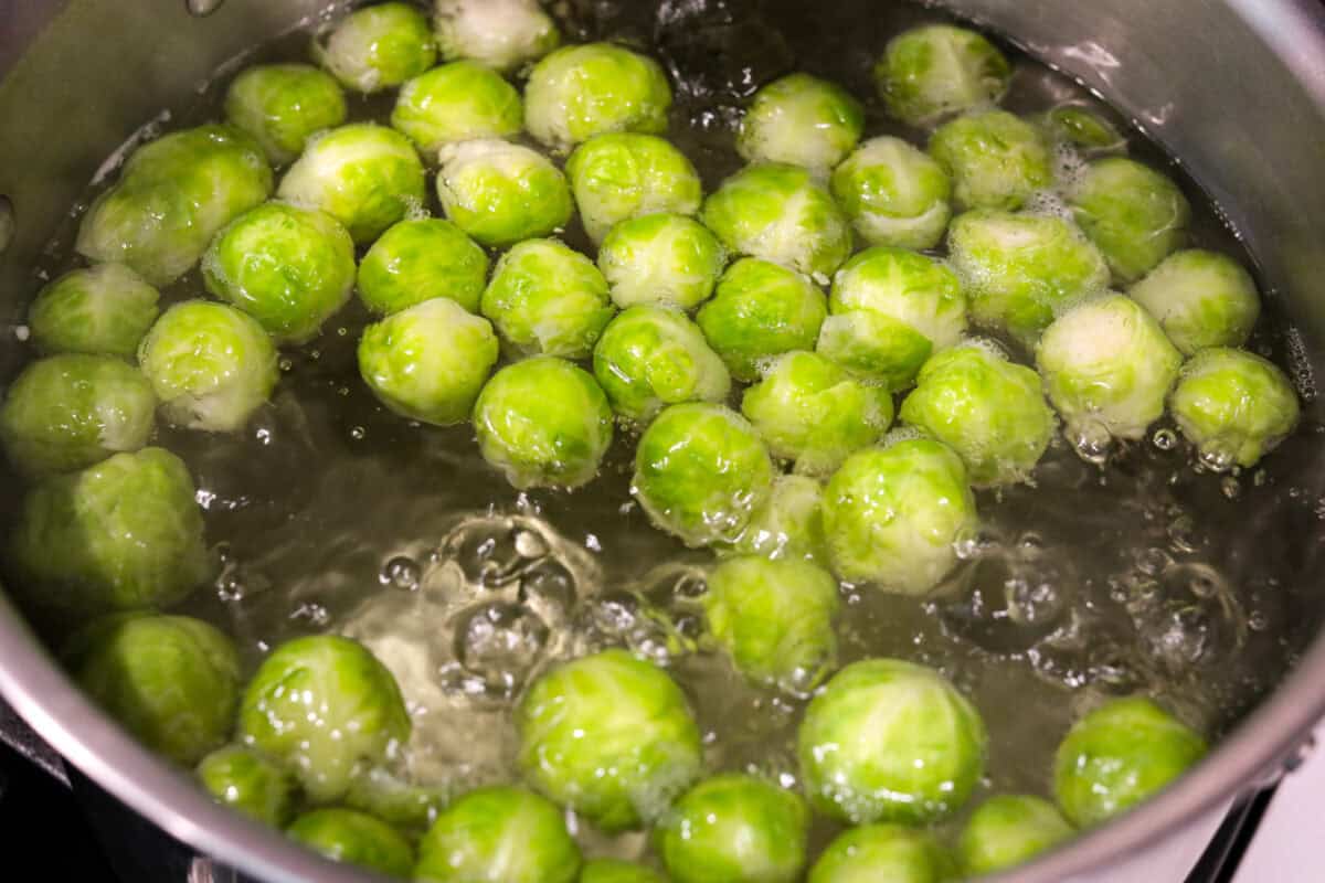 Overhead shot of Brussels sprouts being boiled in water. 