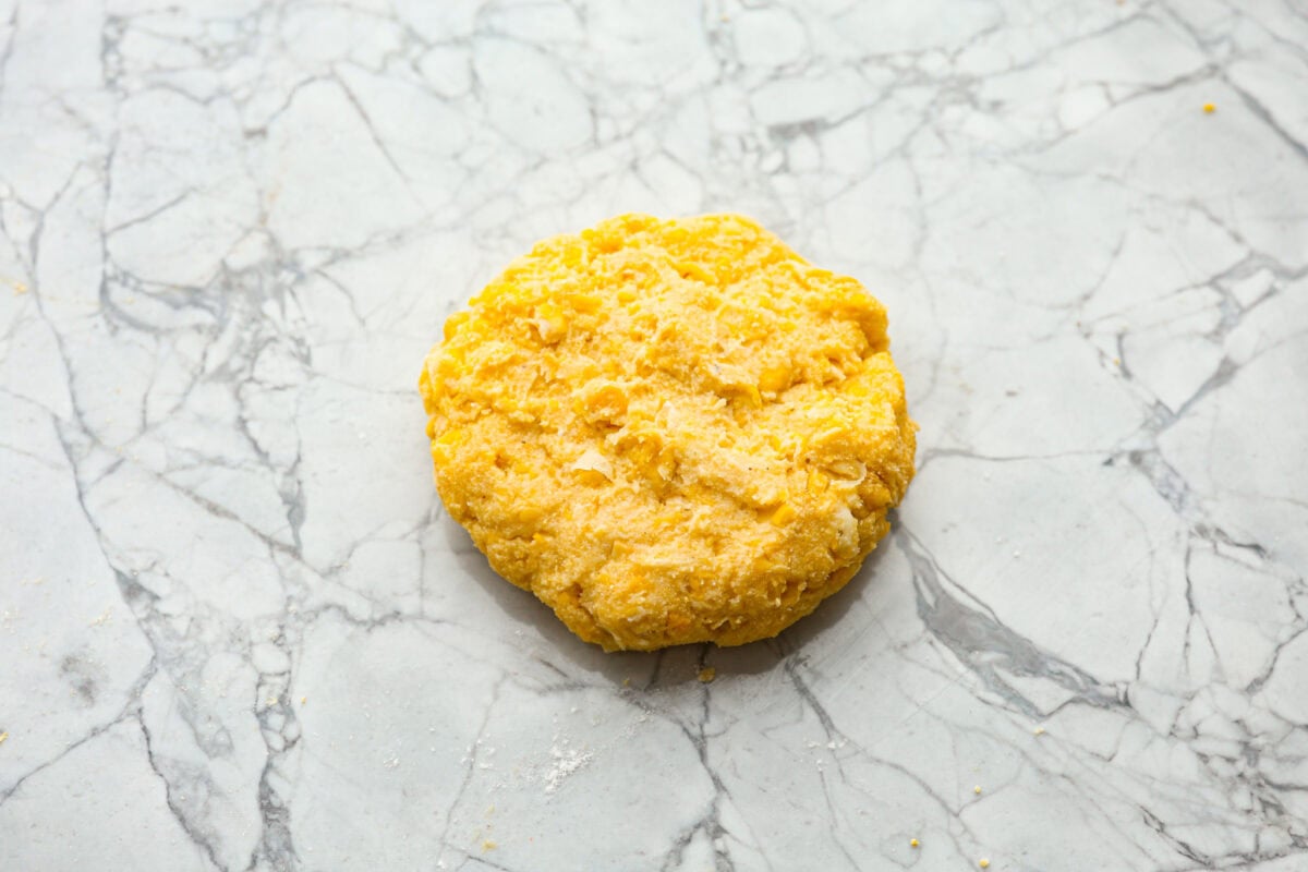 Overhead shot of formed corn cake on a counter top. 