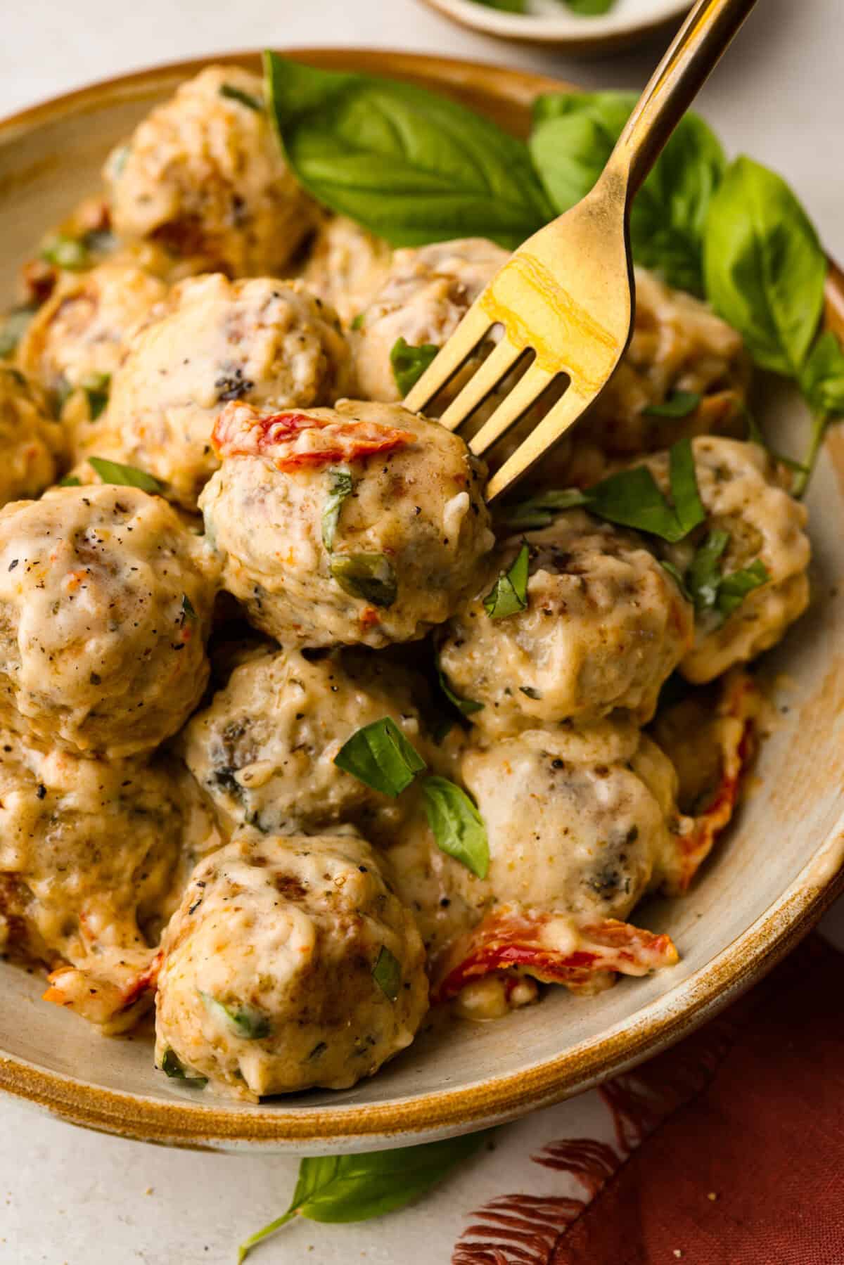 Close up shot of plated marry me meatballs with a fork in one of them. 