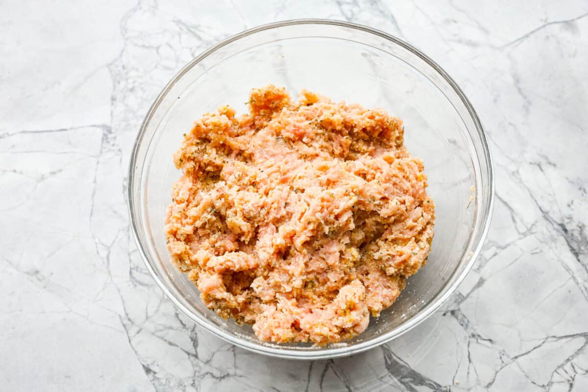 Overhead shot of meatball ingredients mixed together in a bowl. 