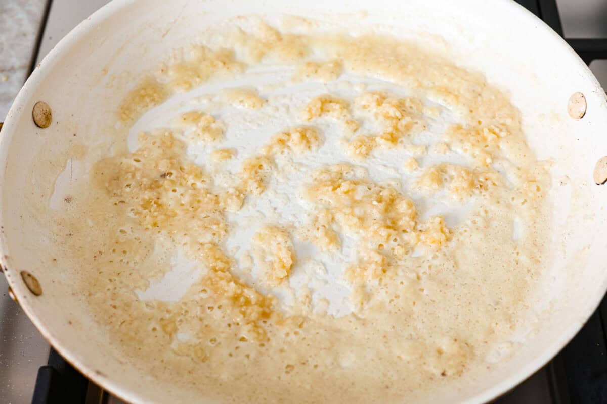 Overhead shot of butter, flour and garlic in a pan. 