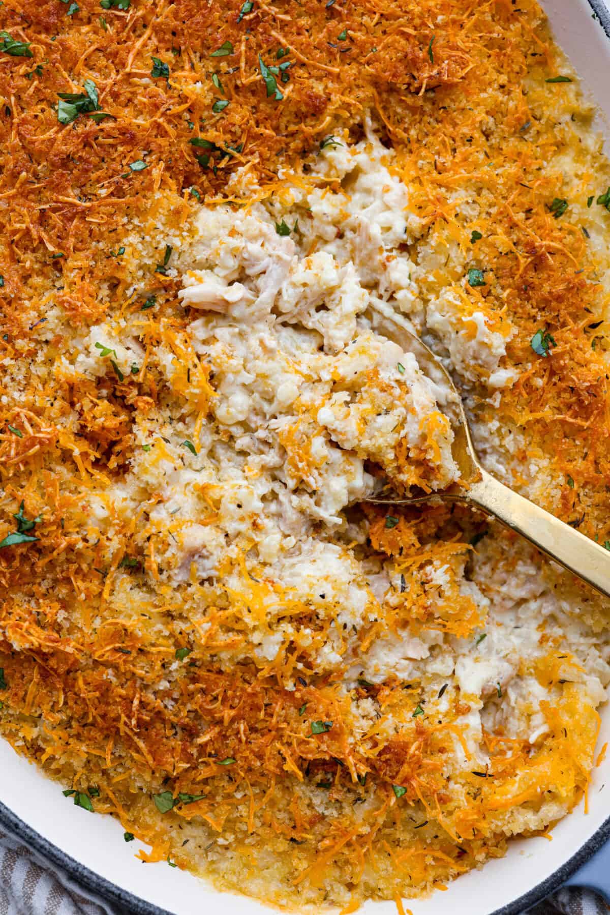 Close up shot of angel chicken and rice casserole with a serving spoon taking out a scoop. 