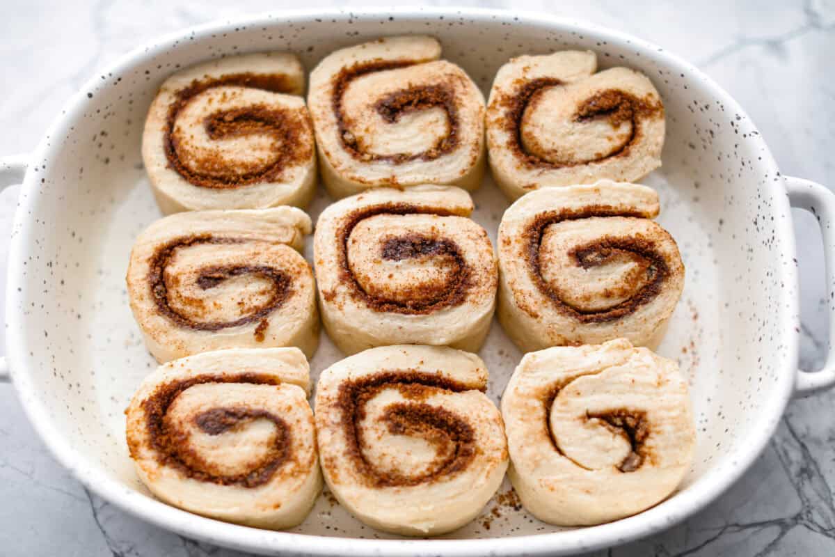 Overhead shot of biscuit cinnamon rolls on their side in baking dish. 