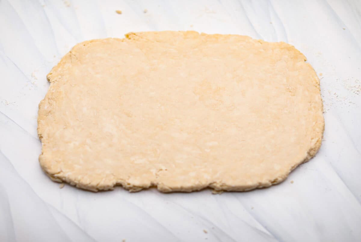 Overhead shot of biscuit dough rolled out into a rectangle. 