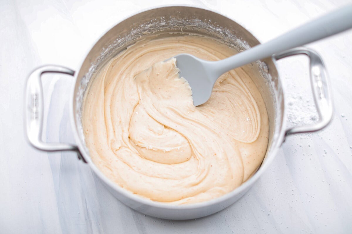 Overhead shot of the powdered sugar, vanilla and milk being mixed with the butter. 