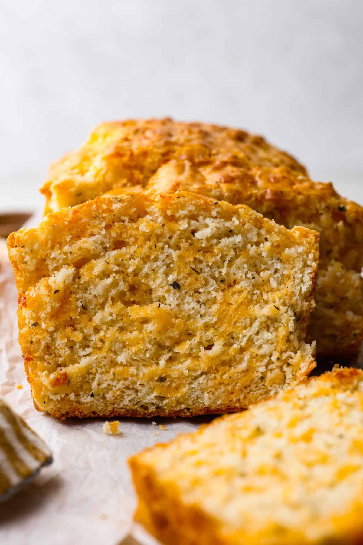 Close up shot shot of a slice of cheesy quick bread.