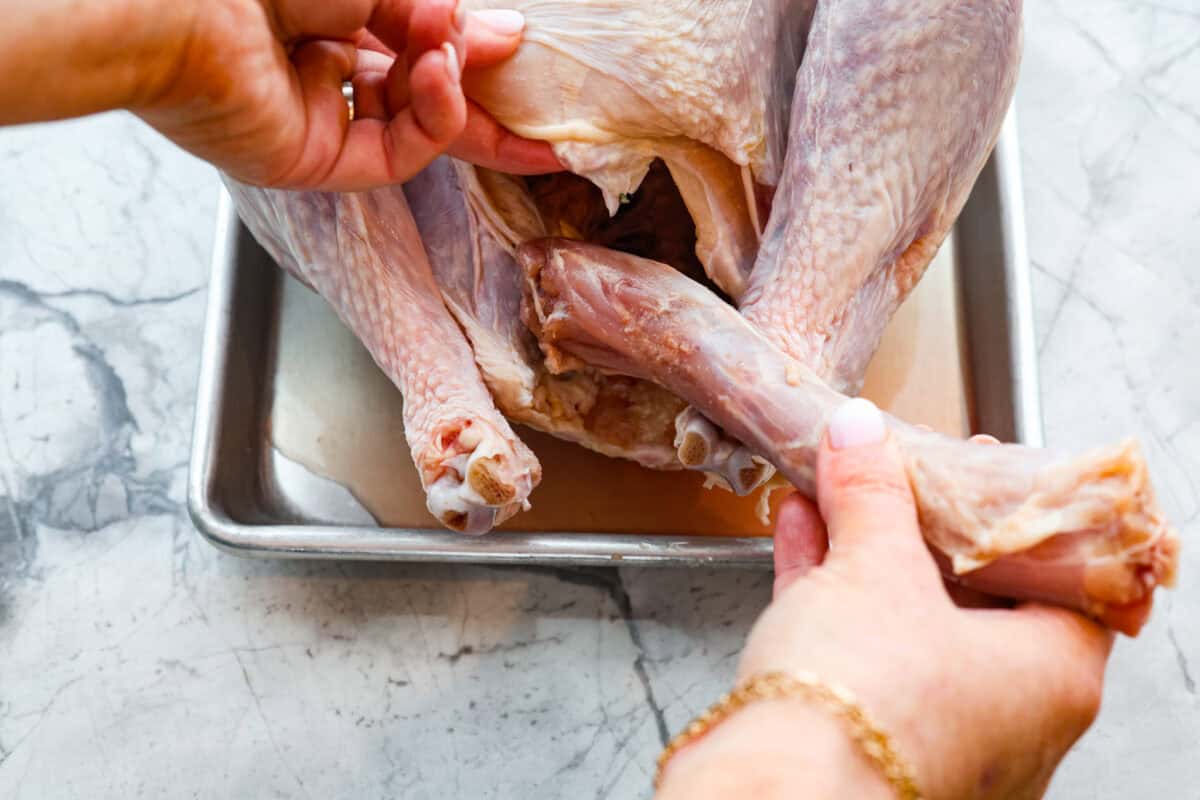 Overhead shot of someone prepping the turkey by taking the giblets out. 