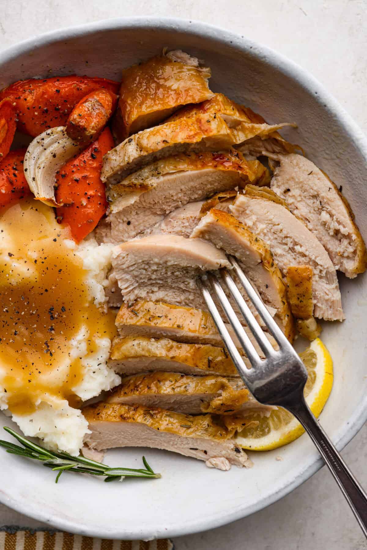 Overhead shot of plated dry brine. turkey with a side of mashed potatoes and gravy, and roasted vegetables. 