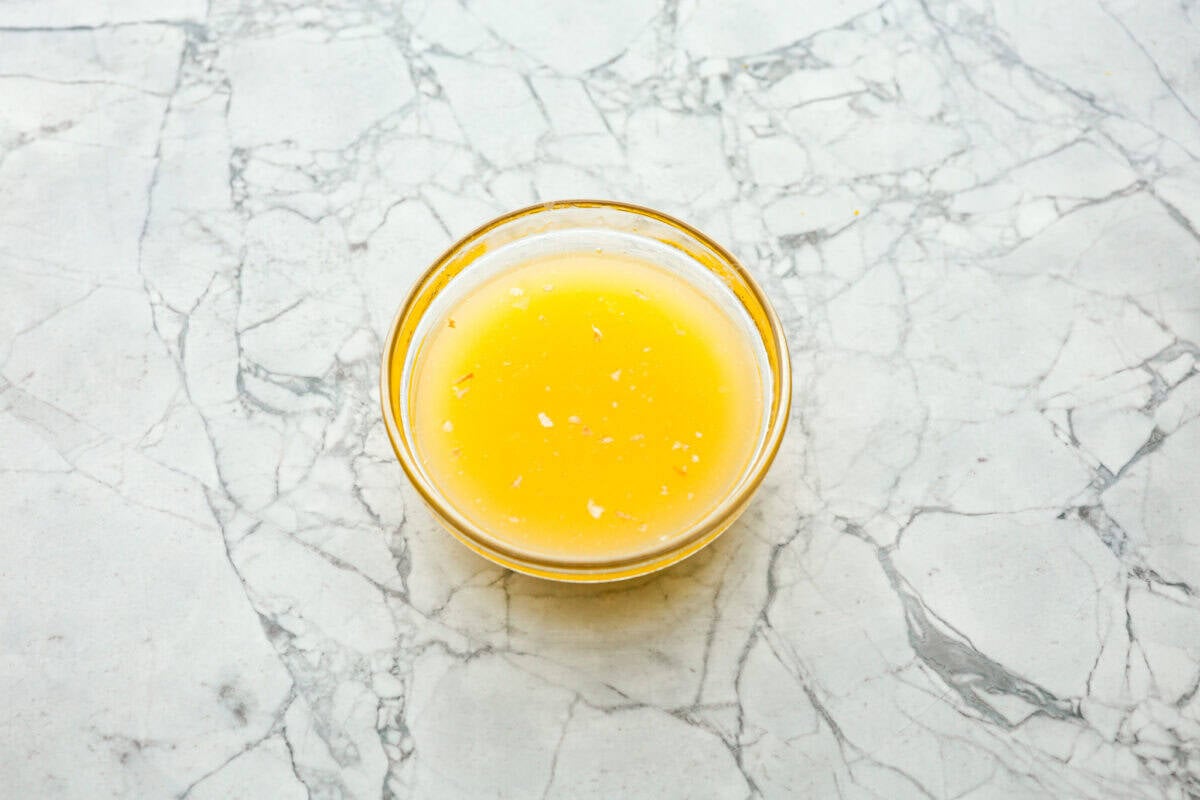 Overhead shot of melted butter and seasonings in a small glass bowl. 