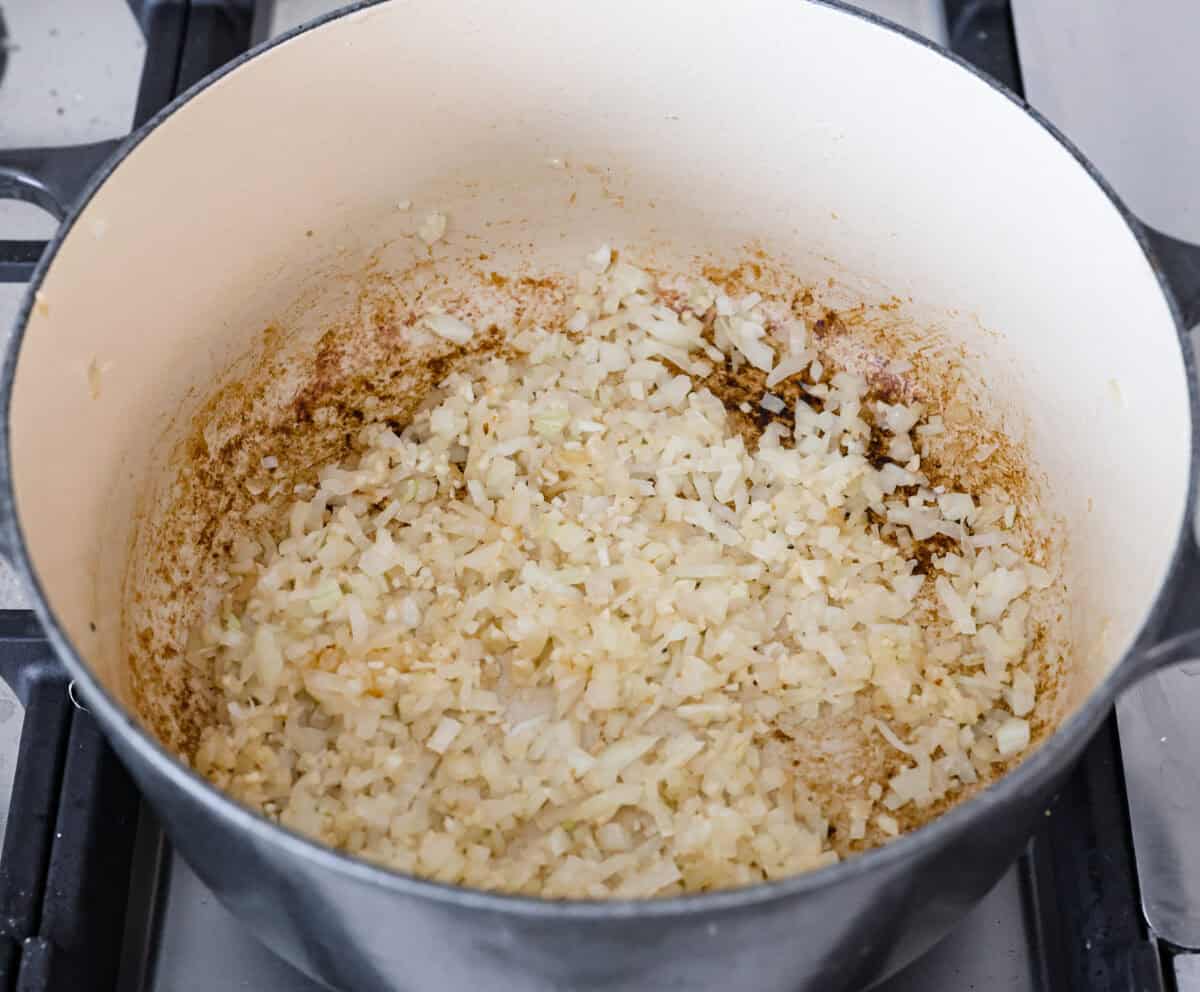 Overhead shot of onions cooking in a pot. 