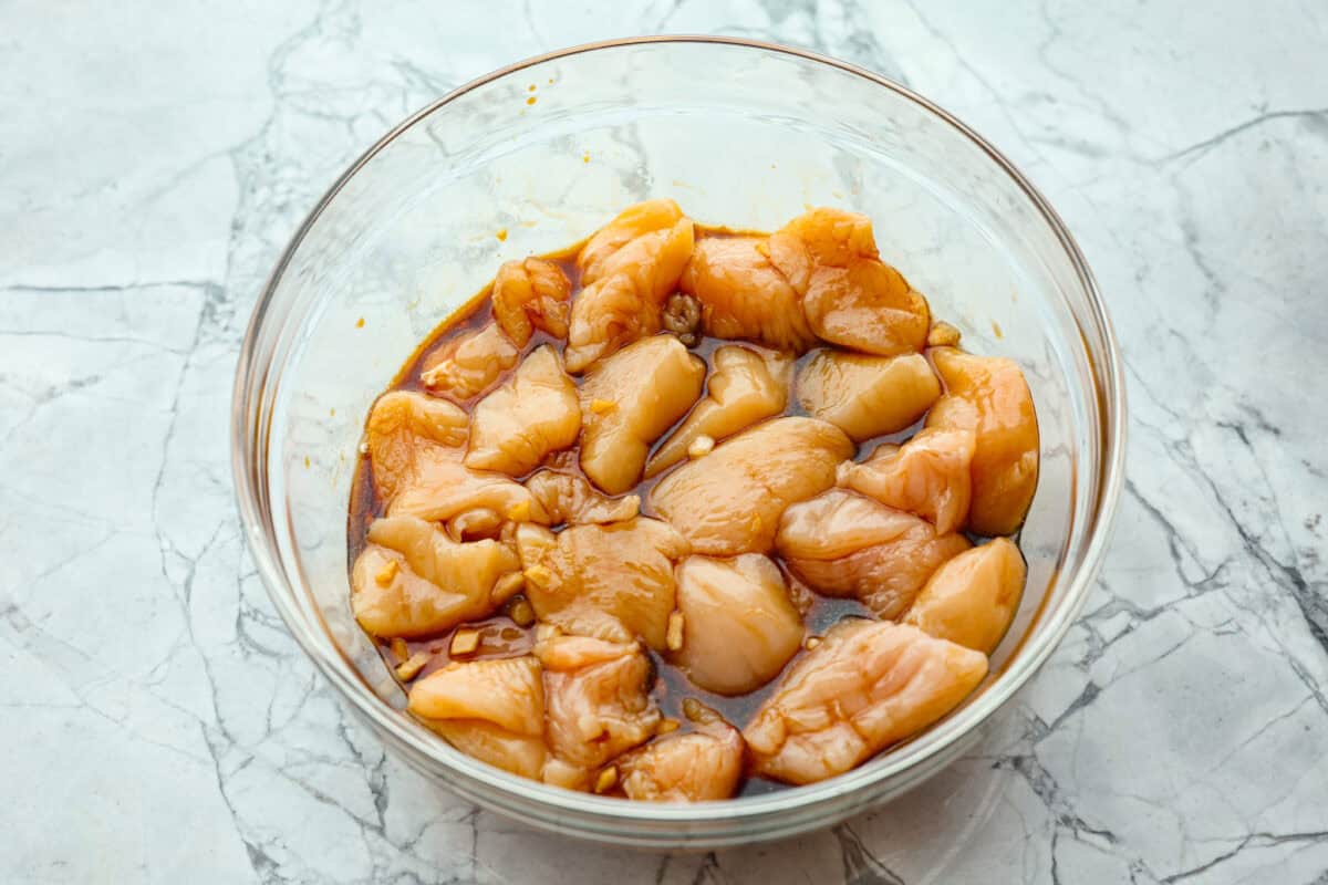 Overhead shot of raw chicken pieces in marinade. 