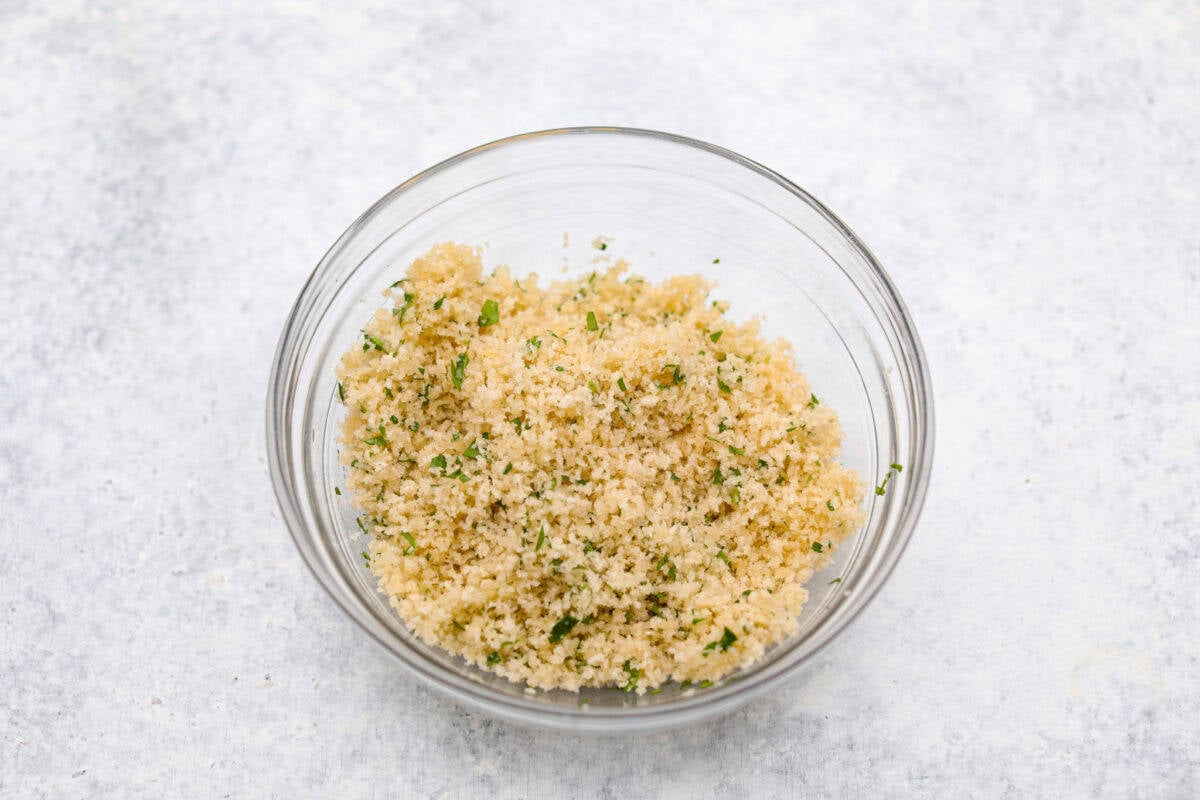 Overhead shot of a bowl with bread crumbs, parsley and butter mixed together. 