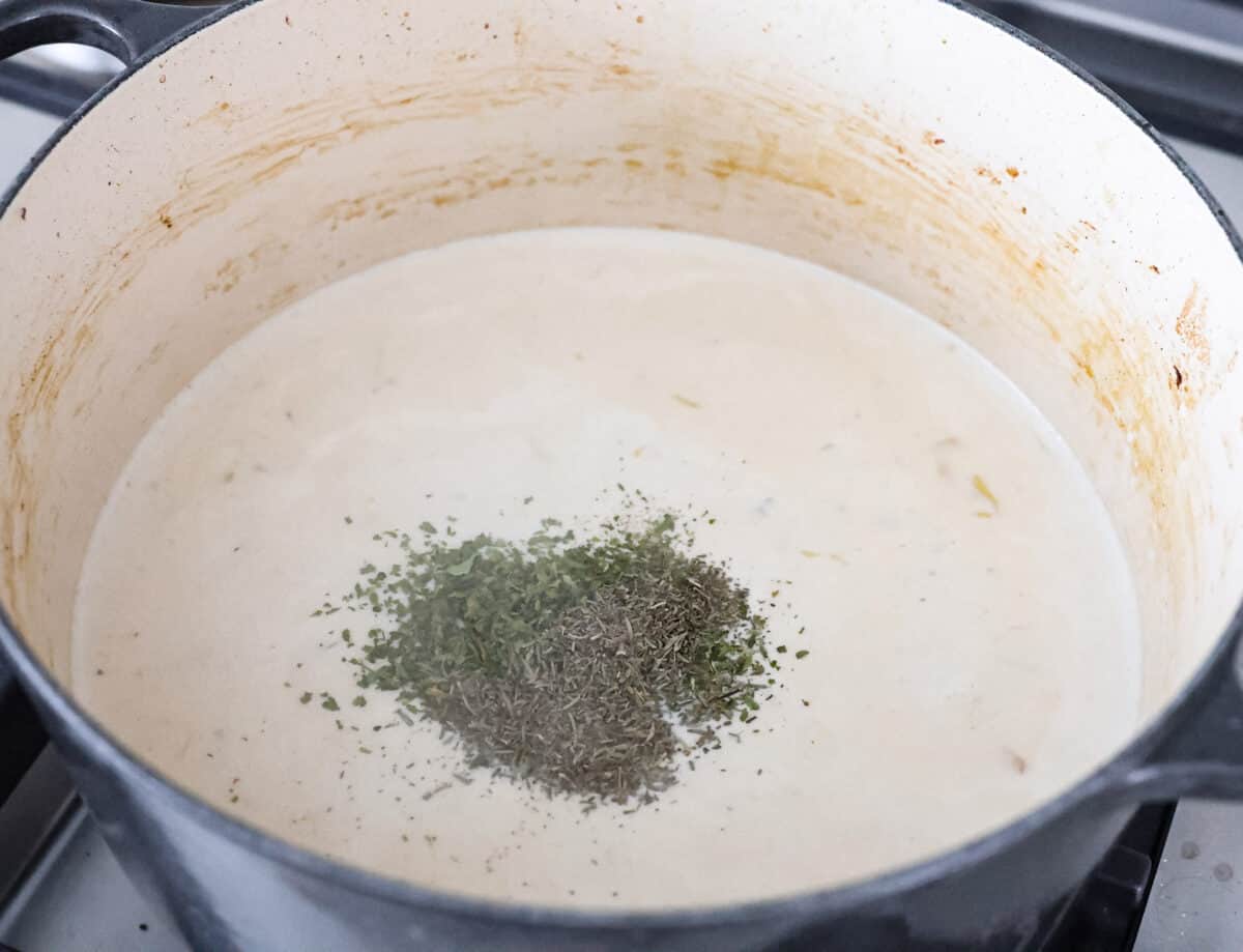 Angle shot of seasonings on top of the sauce in a pot. 