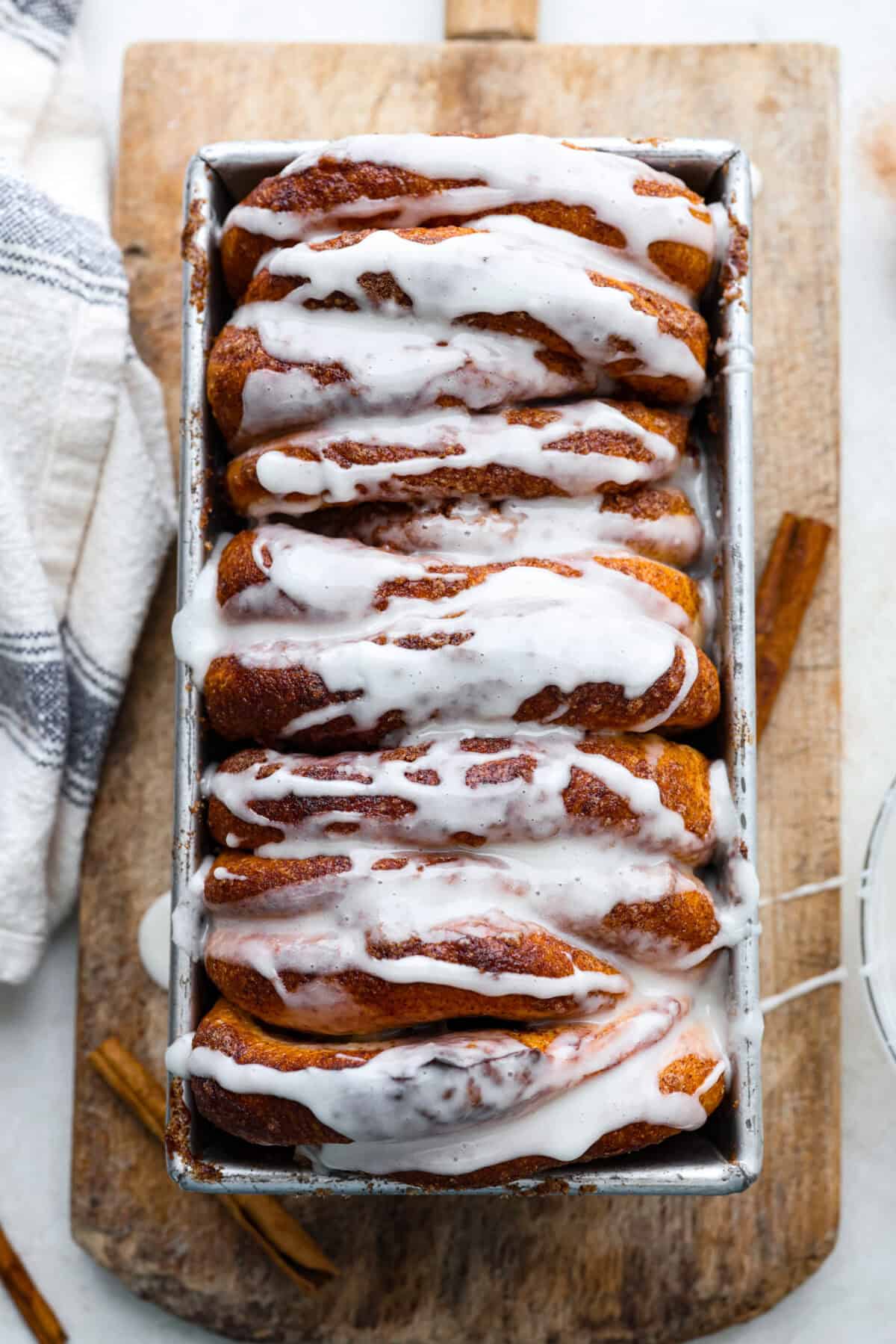 Overhead shot of the cinnamon pull-apart bread in the loaf pan with glaze drizzled over the top.