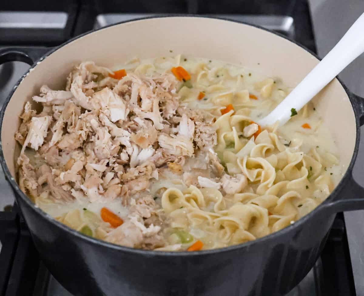 Ange shot of creamy chicken noodle soup with cooked chicken added to it. 