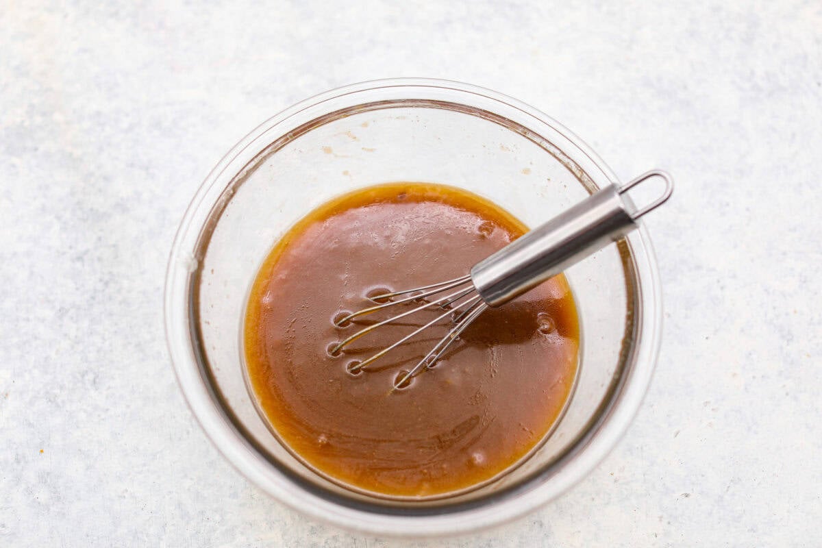 Overhead shot of the melted butter with brown sugar and salt whisked together in a bowl. 