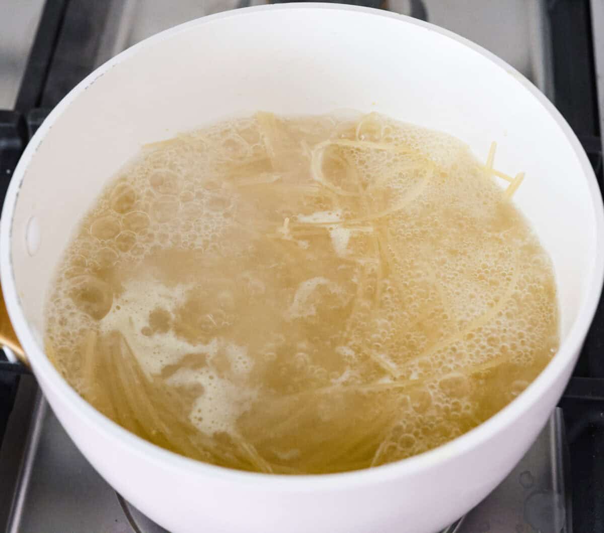 Overhead shot of pasta noodles boiling in a pot. 