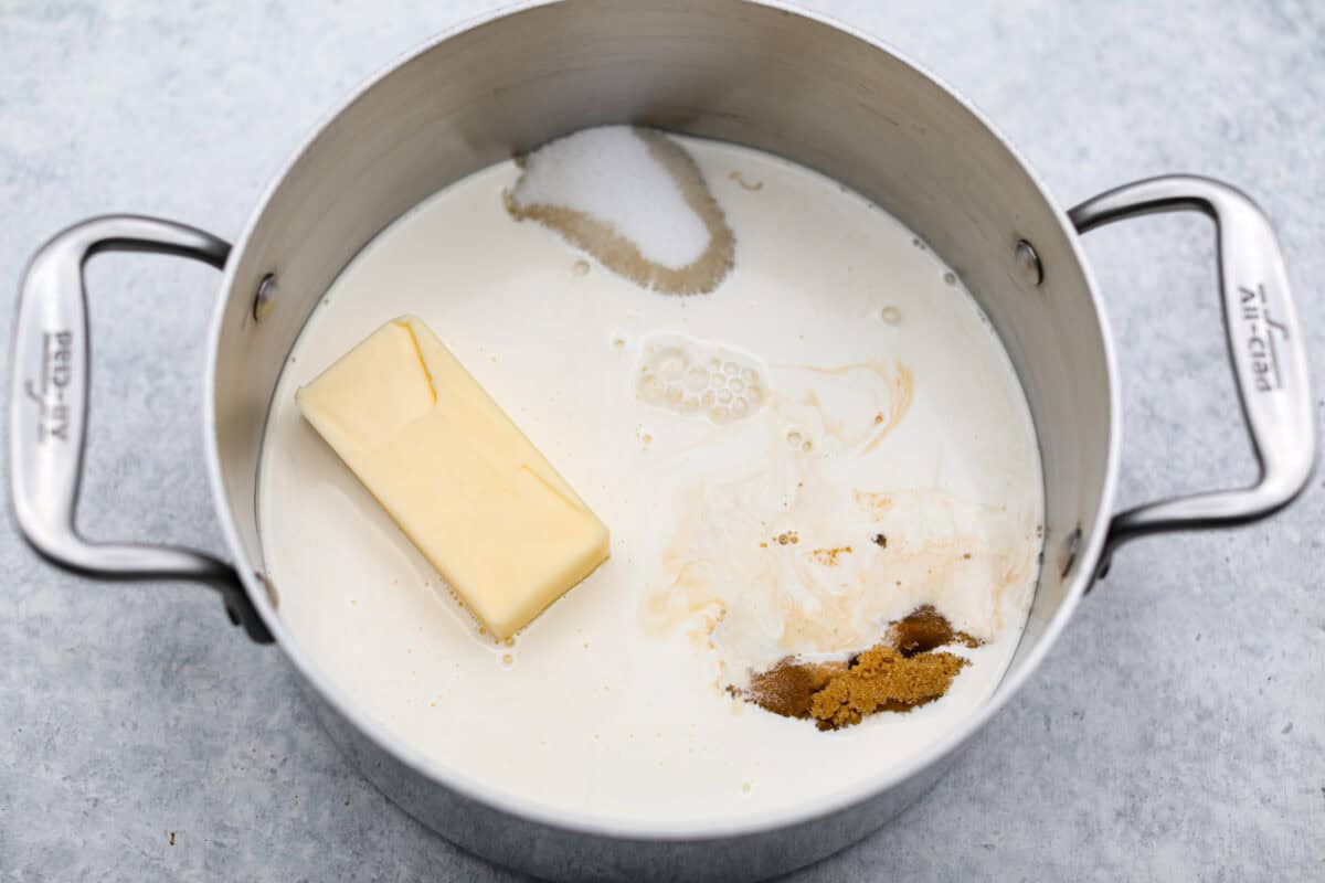 Overhead shot of butter, cream, sugars, corn syrup, evaporated milk and salt in a heavy-bottom saucepan. 