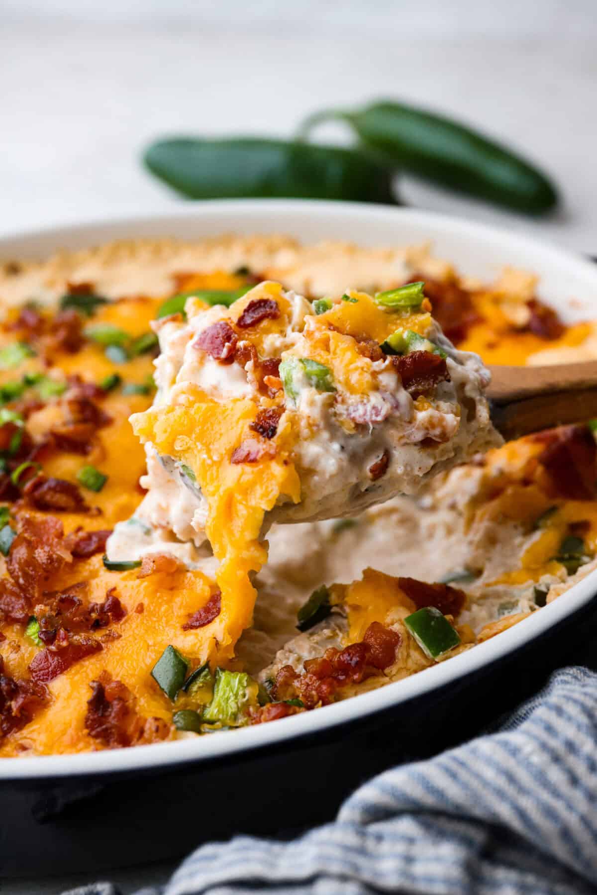 Close up shot of a scoop of Jalapeño popper casserole being lifted out of the baking dish. 