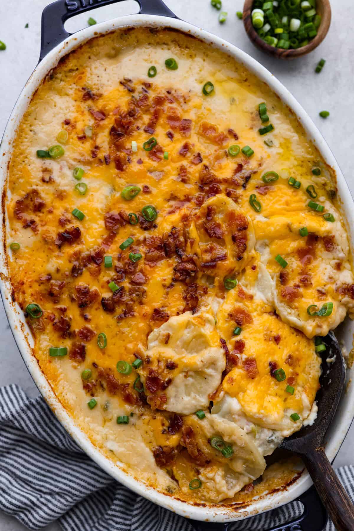 Overhead shot of loaded scalloped potatoes in a baking dish. 