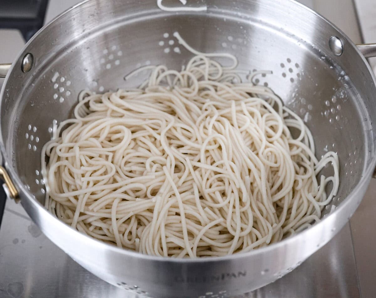 Angle shot of cooked noodles in a colander. 