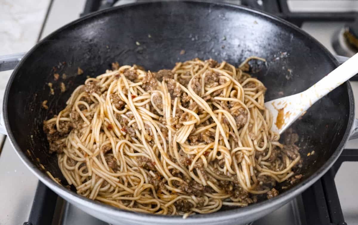 Angle shot of everything being mixed together in a skillet. 