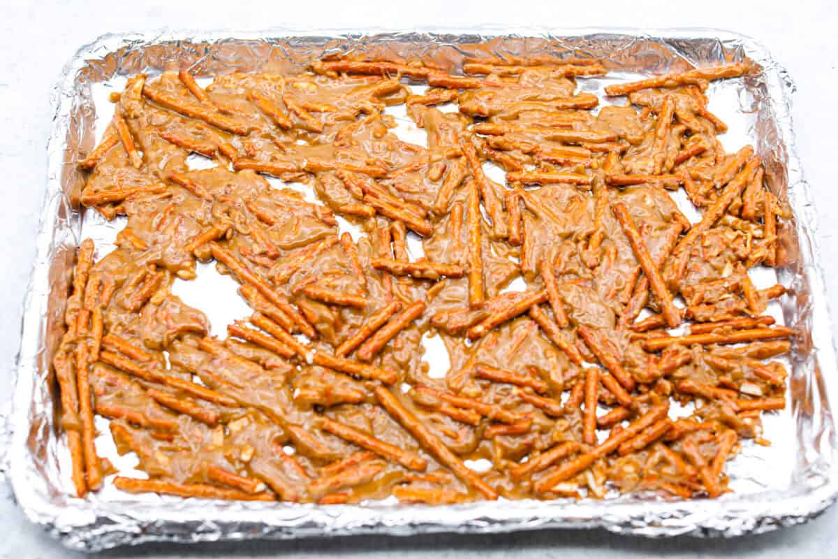 Overhead shot of pretzels and caramel spread out on a baking sheet. 