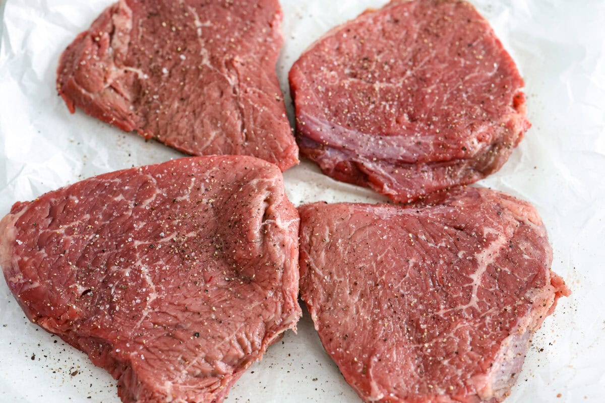 Overhead shot of seasoned steaks. 