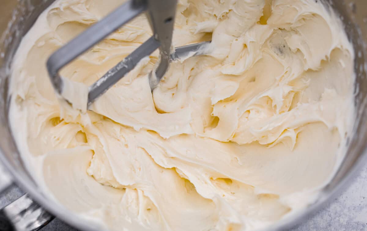 Overhead shot of the coconut frosting being whipped until fluffy in a mixing bowl. 