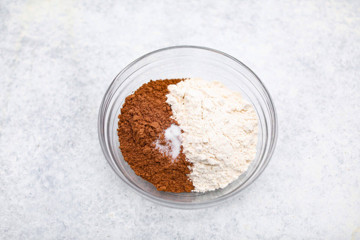 Overhead shot of cocoa and flower in a mixing bowl. 