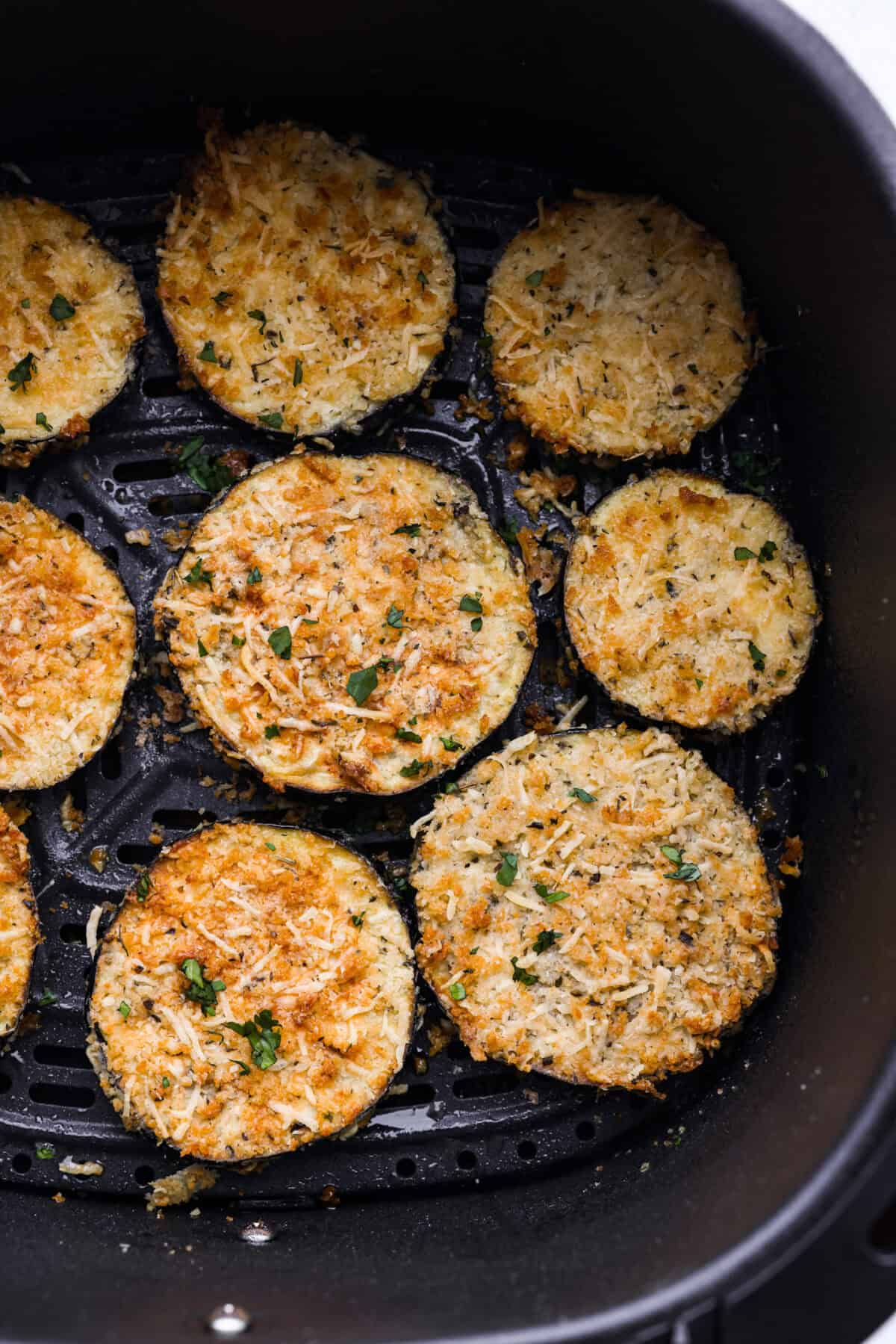 Close up shot of air fried eggplant in the bottom of the air fryer basket. 