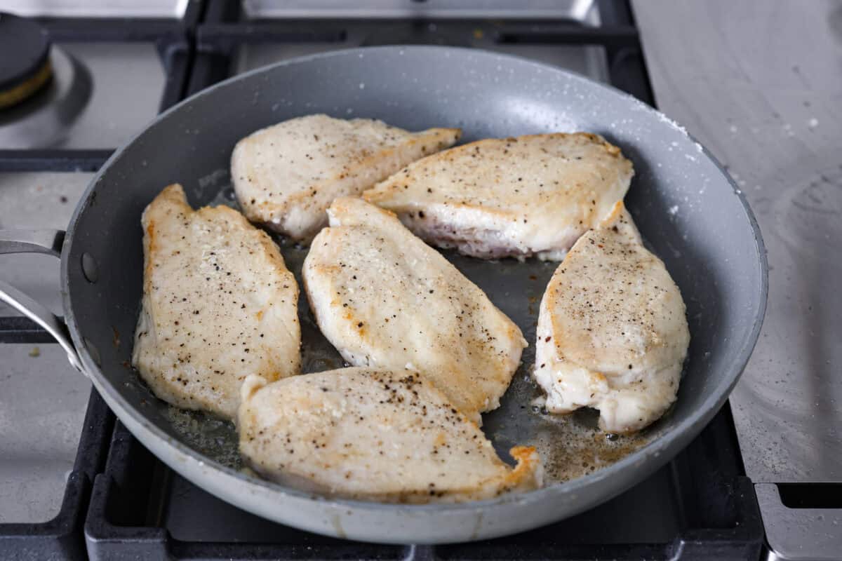 Angle shot of  the chicken cooking in a skillet. 