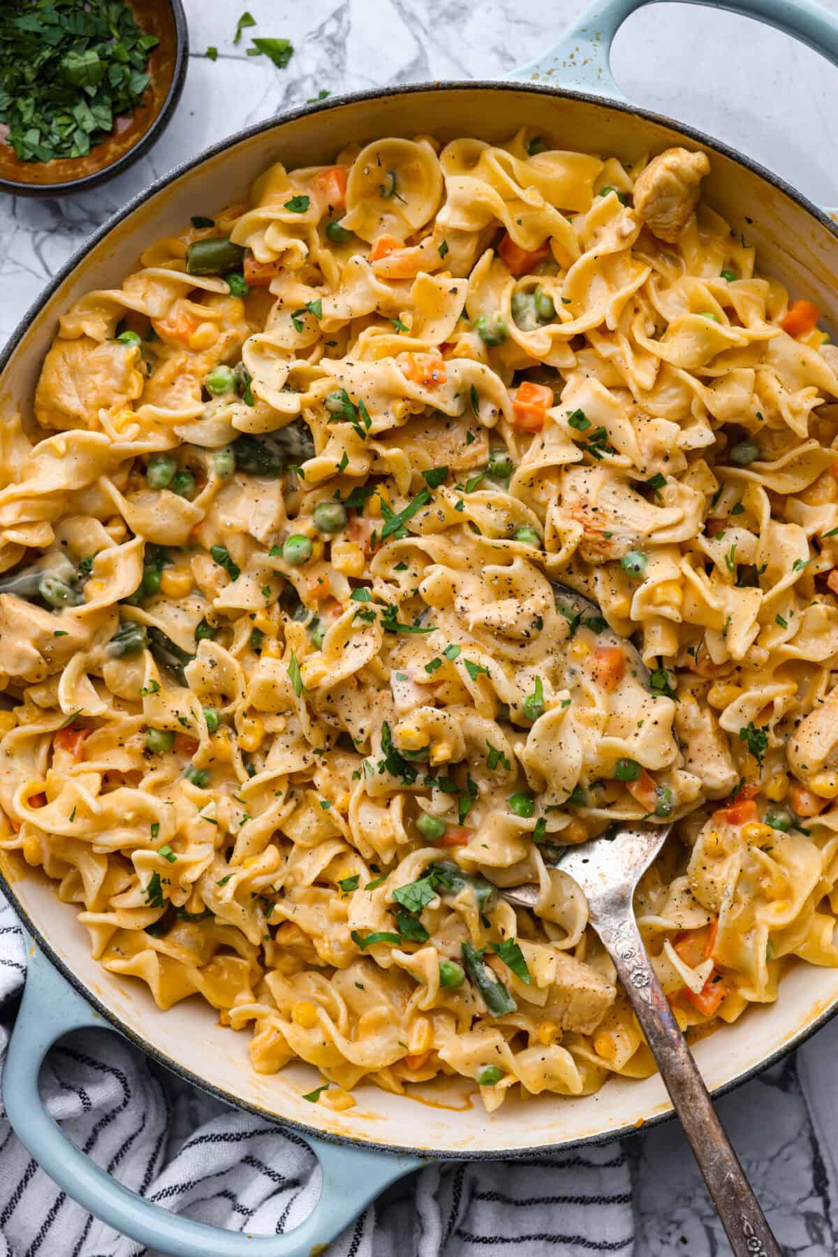 Overhead shot of chicken pot pie pasta in a skillet with serving spoon. 