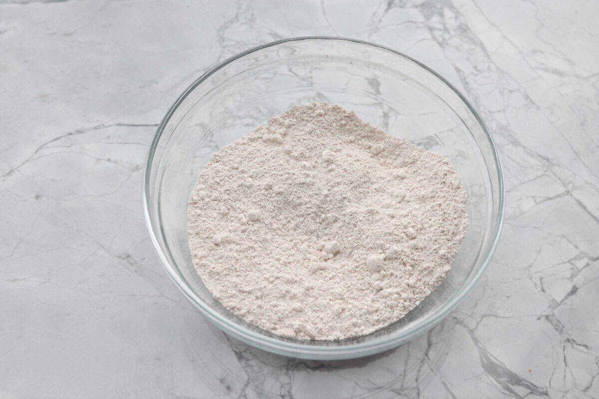 Overhead shot of cinnamon, granulated sugar, and powdered sugar mixed together in a bowl. 