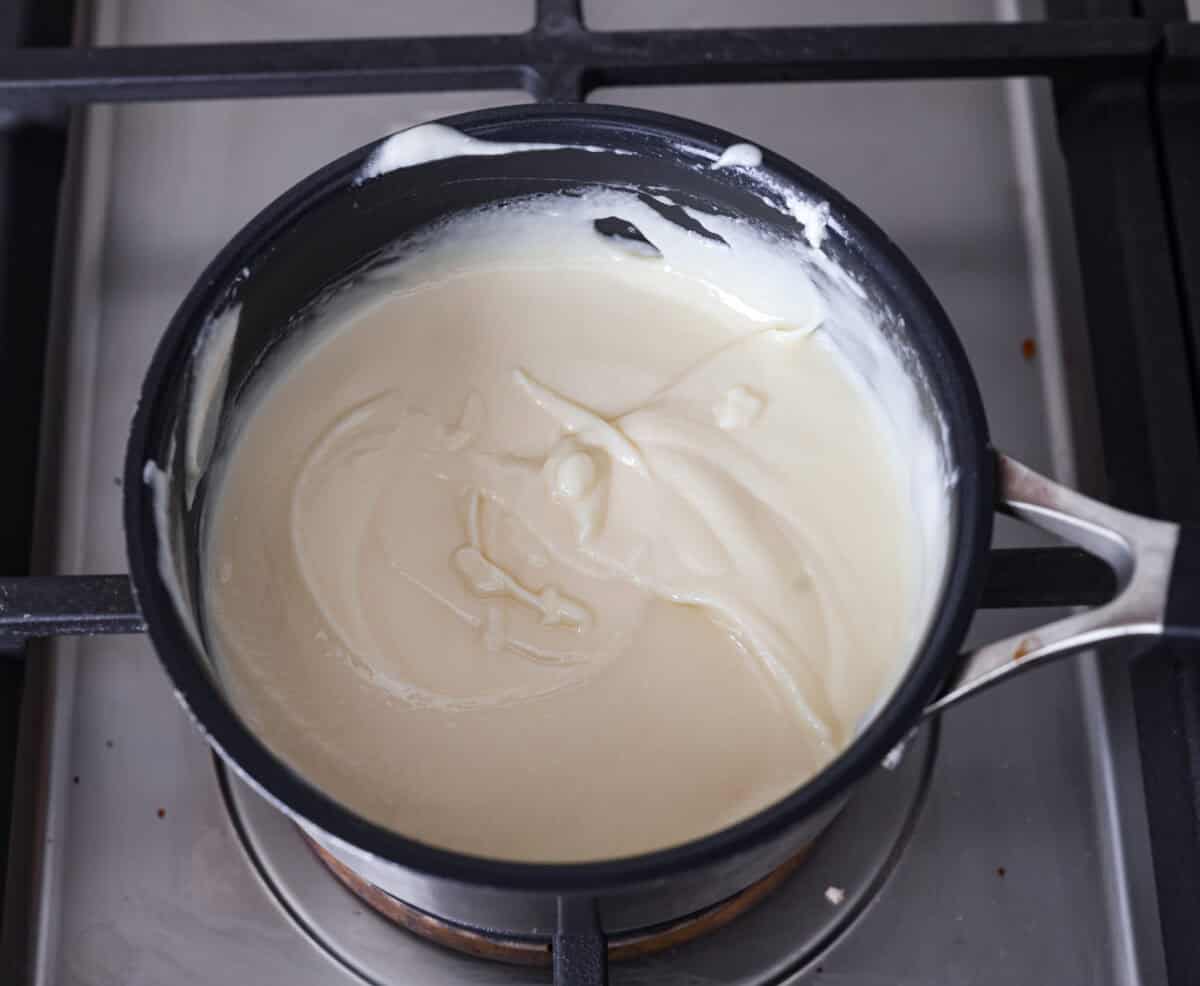 Overhead shot of butter and white chocolate chips melted in a pot. 