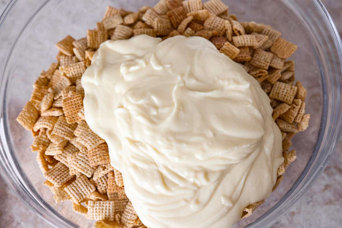 Overhead shot of the melted white chocolate and butter mixture poured over the cereal. 