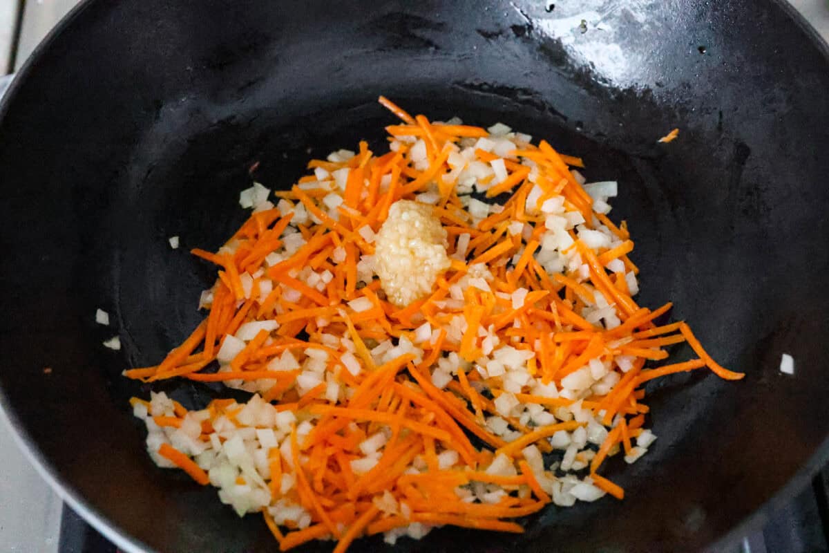 Overhead shot of garlic added to the vegetables in the skillet. 