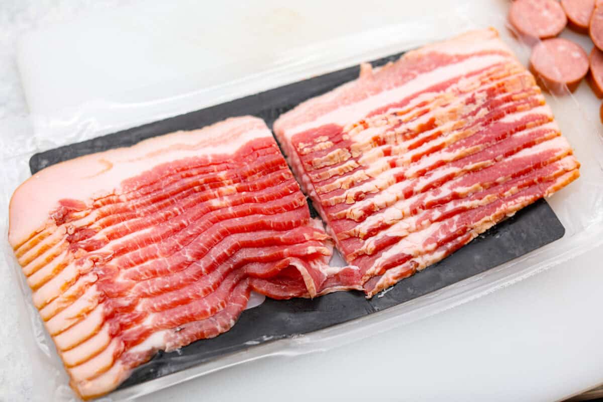 Overhead shot of a pack of thick cut bacon cut in half. 