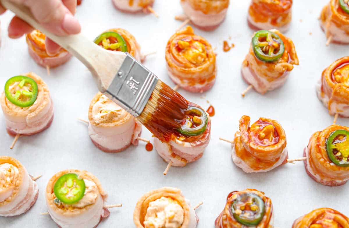 Overhead shot of someone brushing the bbq sauce glaze on the pig shots. 