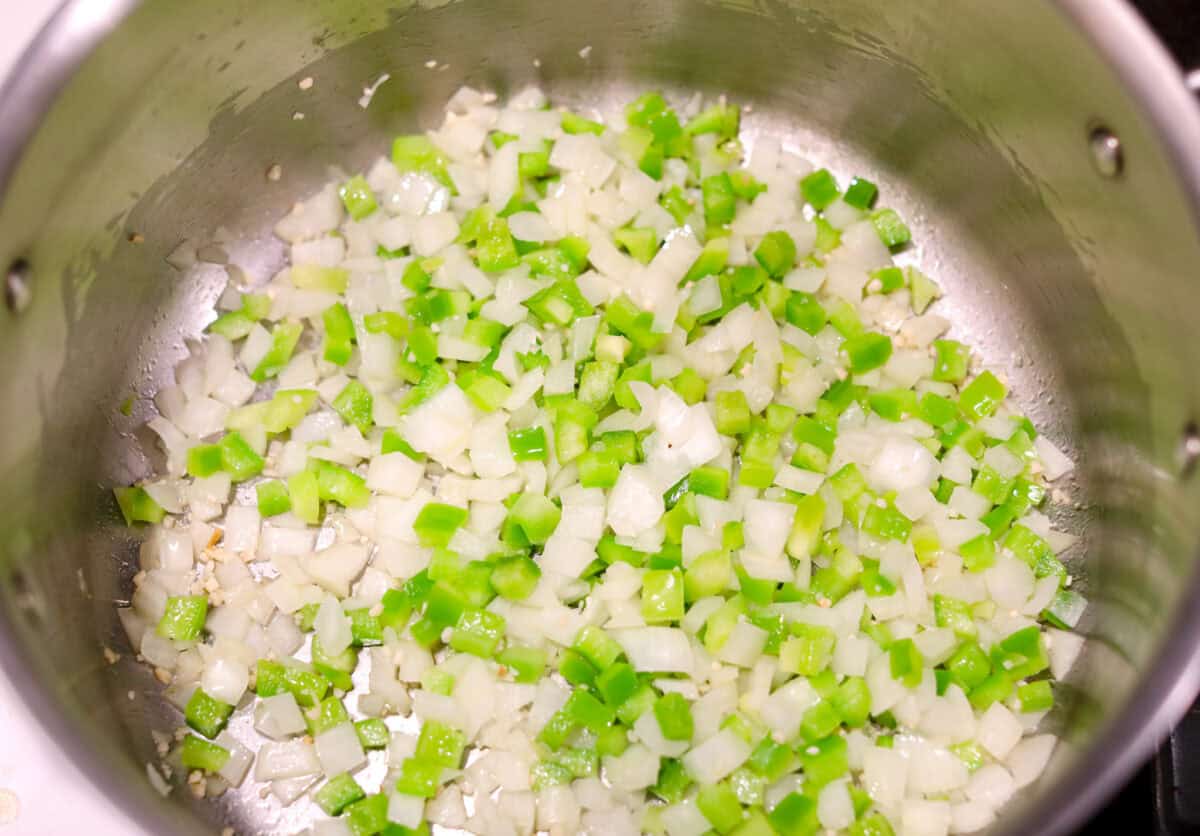 Overhead shot of celery and onion and garlic sautéing in a pot. 