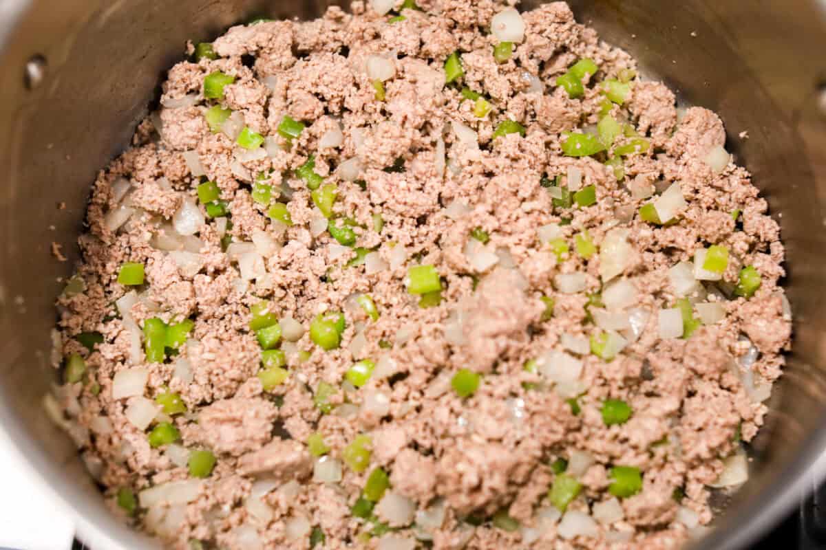 Overhead shot of ground turkey added to the veggies in the pot. 