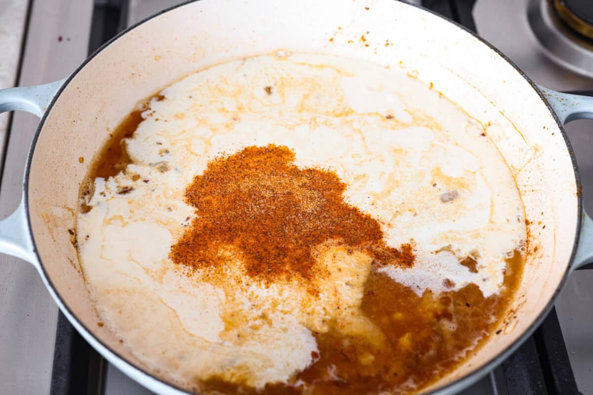 Creamy Cajun Chicken is the perfect combination of bold, zesty flavors and rich, velvety sauce. Juicy, tender chicken is coated in a perfectly spiced Cajun seasoning and simmered in a luscious, creamy sauce that’s packed with flavor. Angle shot of cream, broth, cheese and seasonings added to the skillet.