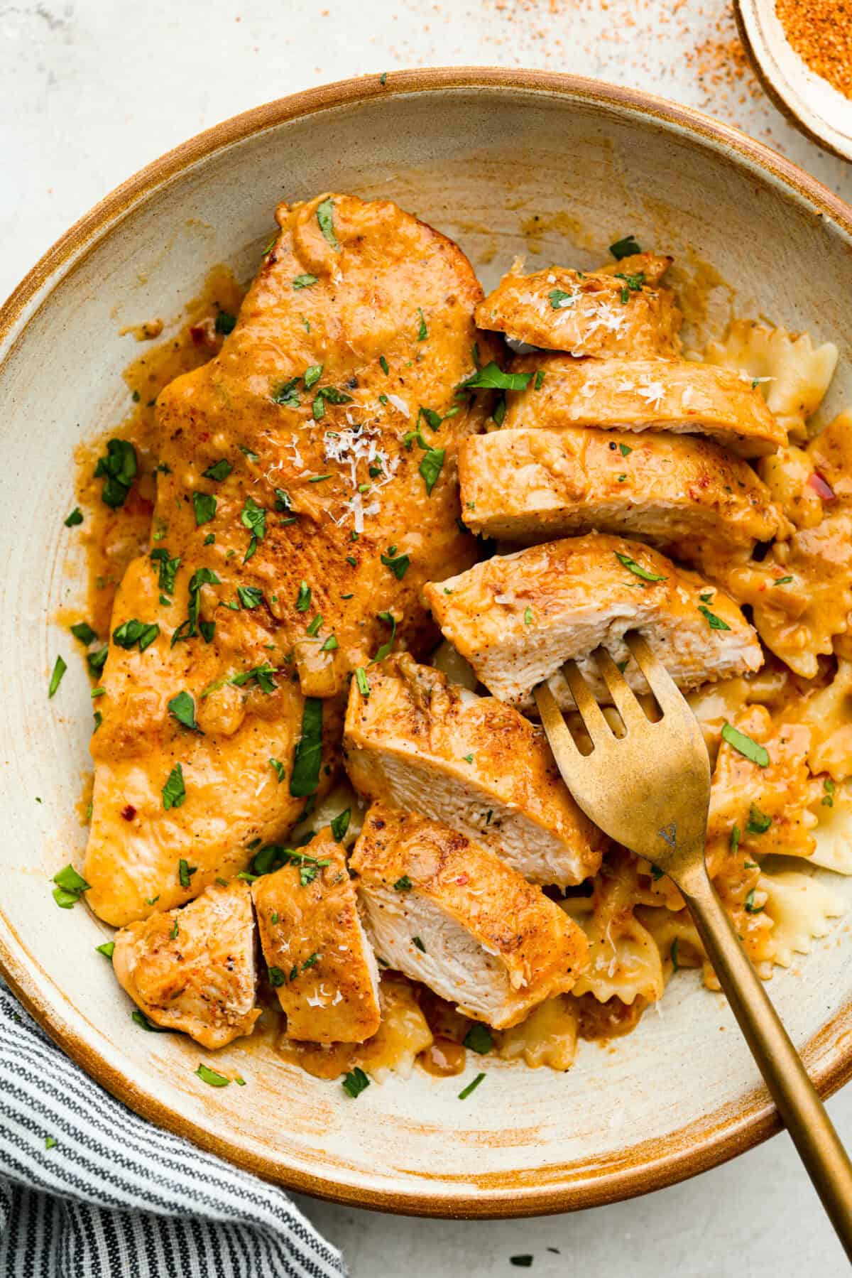 Creamy Cajun Chicken is the perfect combination of bold, zesty flavors and rich, velvety sauce. Juicy, tender chicken is coated in a perfectly spiced Cajun seasoning and simmered in a luscious, creamy sauce that’s packed with flavor. Overhead shot of plated creamy cajun chicken over bowtie pasta.