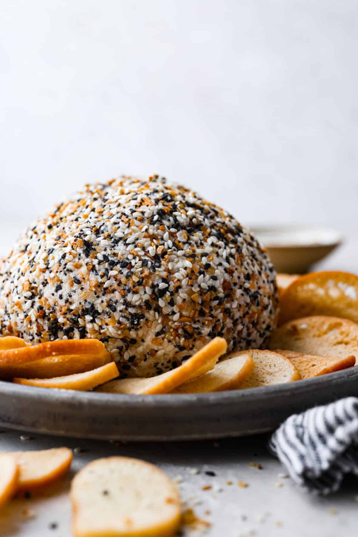 Side shot of the everything bagel cheese ball on a platter. 